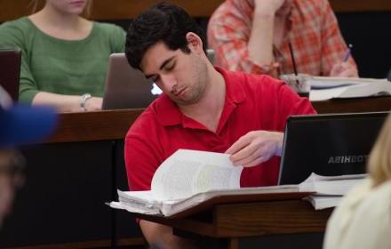 Law student looks through notes while in class.